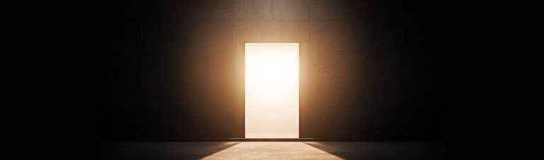 Dödsbon i Stockholm - Vi hjälper dig Bild på en dörr som öppnas i ett mörkt rum. Symboliserar livet efter döden då sidan handlar om dödsbon.